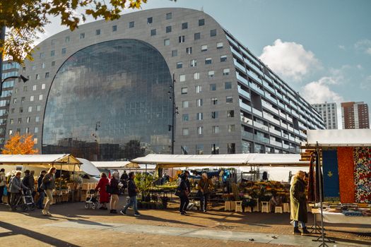 Modieuze shoppers in Rotterdamse winkelstraat met streetwear, oversized blazers en zomerse accessoires