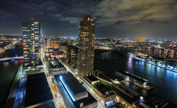 Jong stel kijkt Netflix op de bank in een modern appartement in Rotterdam met stadslichten op de achtergrond