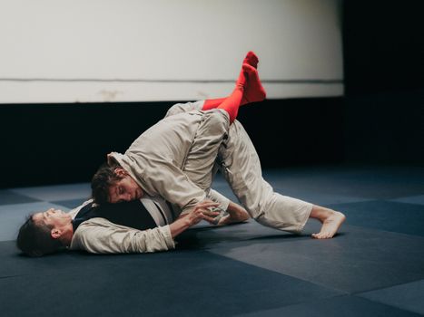 Fight sports jiu jitsu Rotterdam training in een sporthal met matten en sparrende vechtsporters